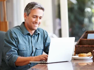 man using laptop to find out how he can finance lasik eye surgery