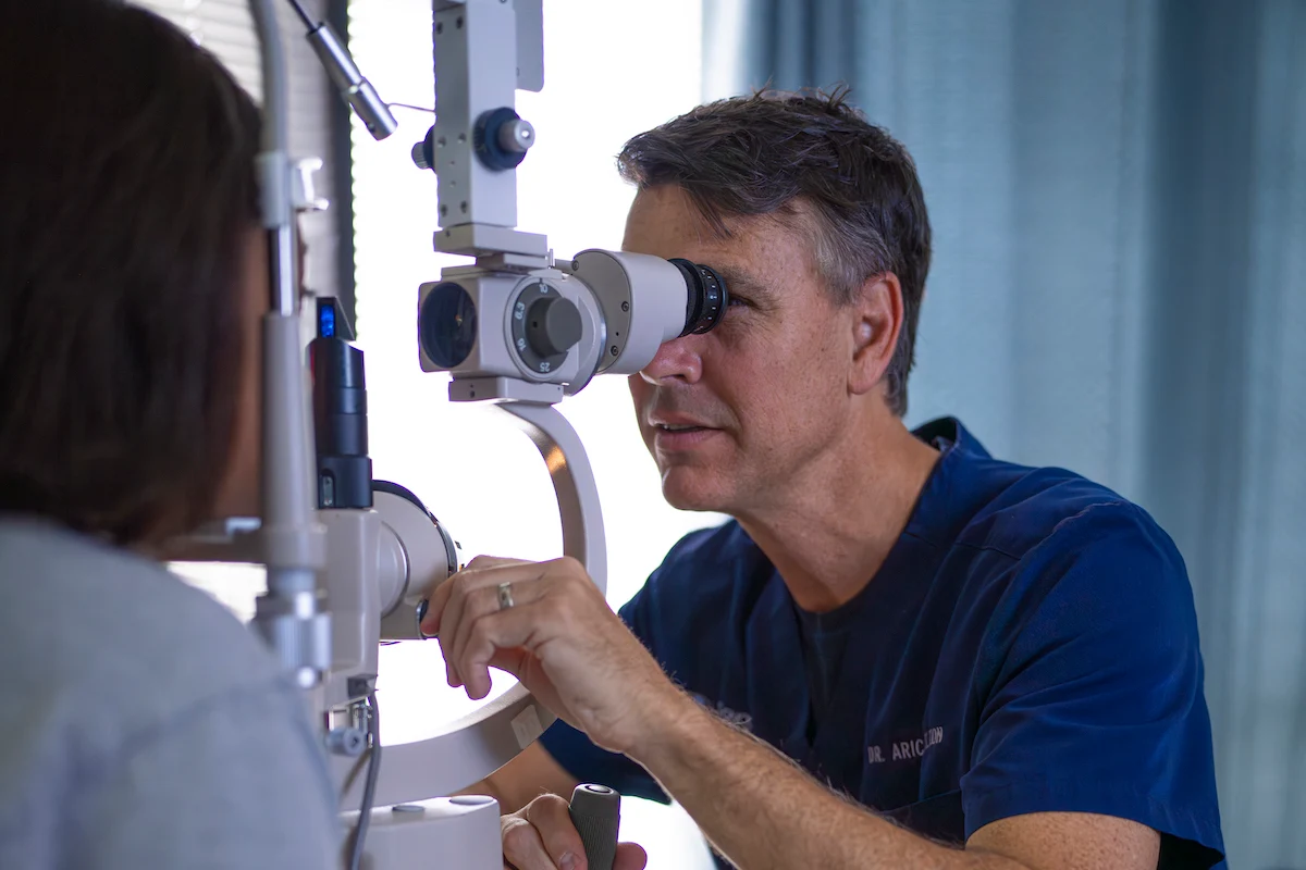 Dr. Welton using split lamp on patient